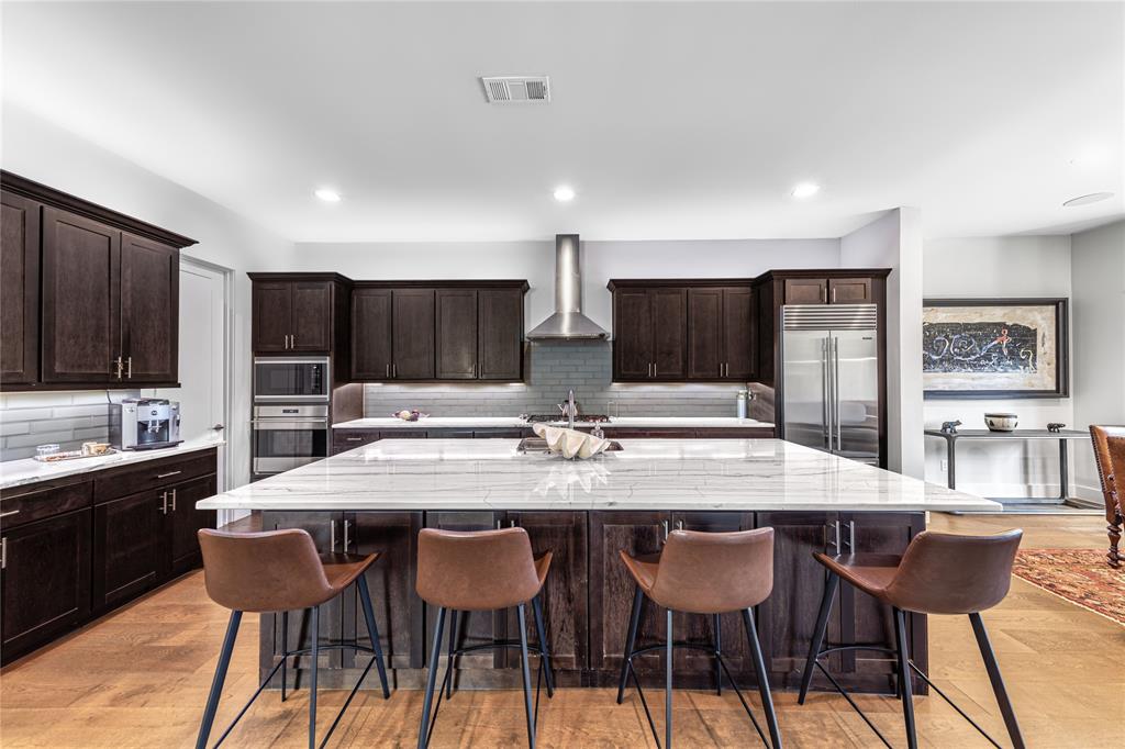 4144 Entrada Way Dallas, TX 75219 - Photo 7 of 34 a kitchen with stainless steel appliances kitchen island granite countertop a dining table chairs sink and cabinets