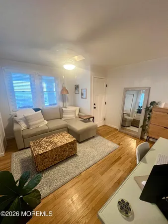a bedroom with a bed couch and wooden floor