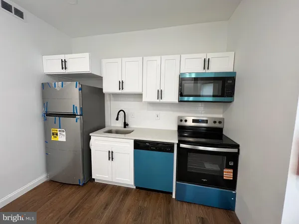 a kitchen with a sink and steel appliances