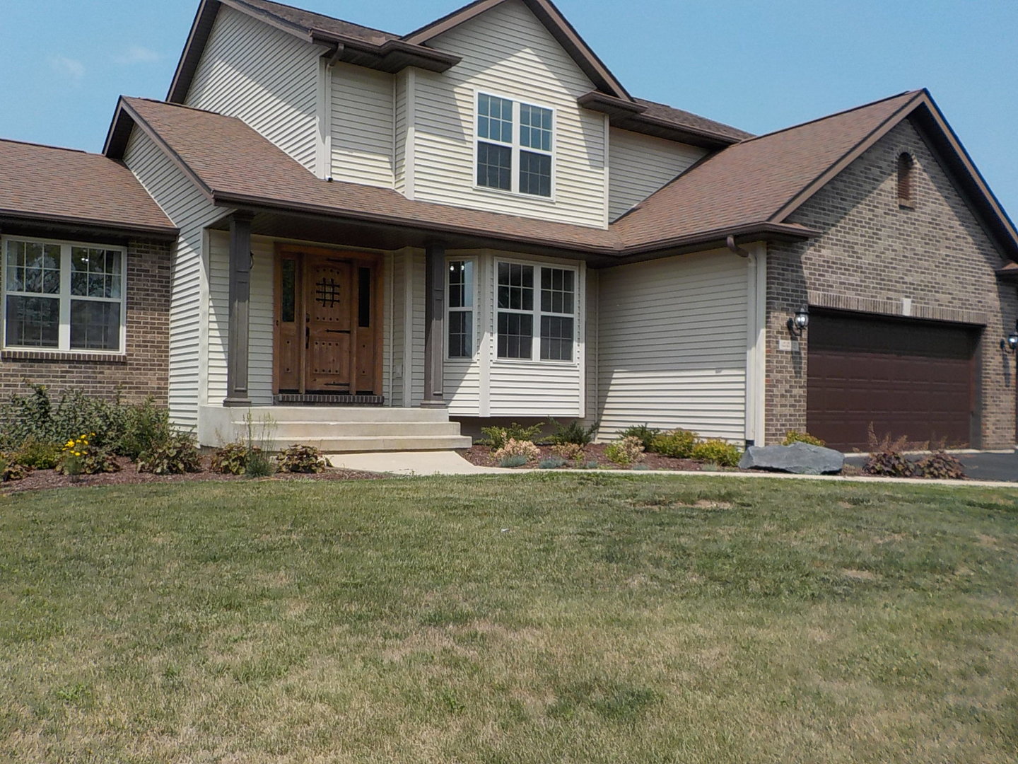 4412 Ridgeview Lane Byron, IL 61010 - Photo 2 of 35 a front view of a house with a garden and yard