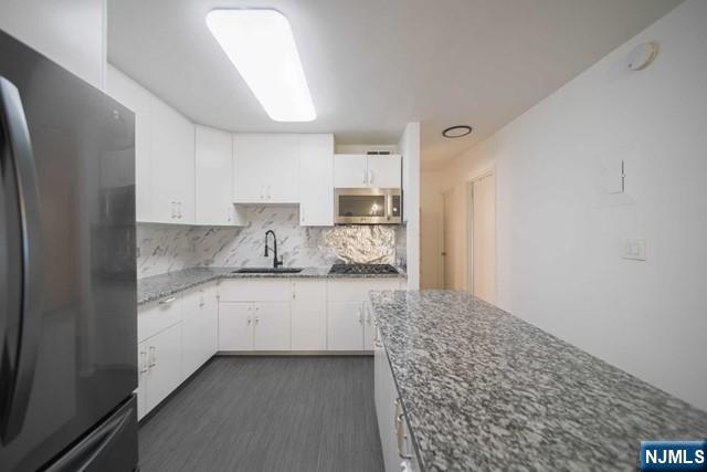 2100 Linwood Avenue, Unit 17T Fort Lee, NJ 07024 - Photo 7 of 17 a large kitchen with granite countertop a sink and a stove top oven
