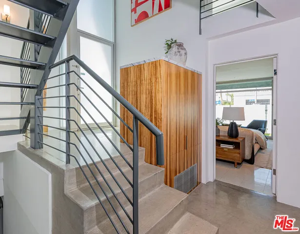 a spacious bedroom with a bed and a large mirror