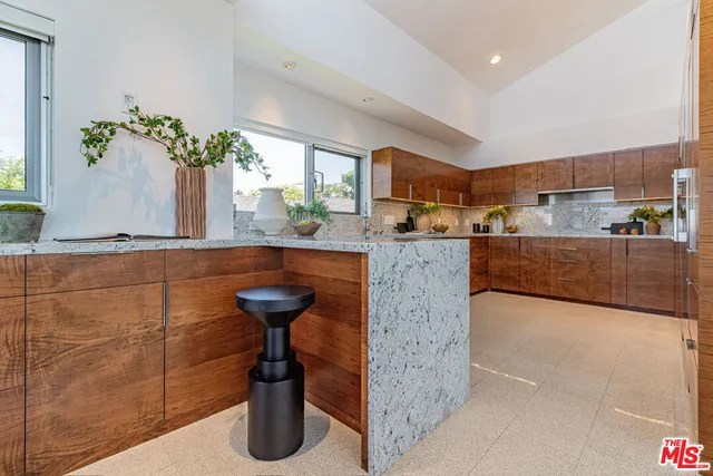 a kitchen with granite countertop a refrigerator and a sink