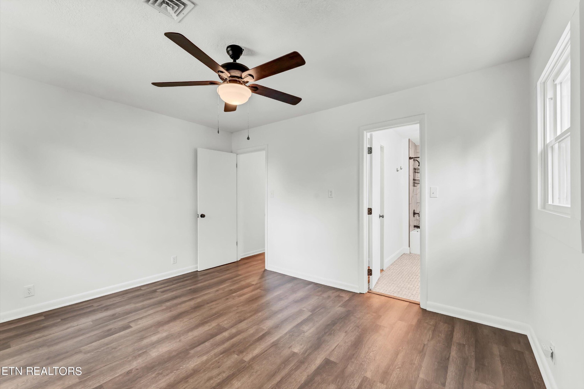 133 Londonderry Road Knoxville, TN 37923 - Photo 16 of 35 an empty room with wooden floor fan and windows
