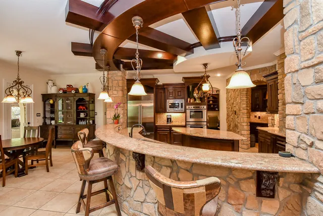 a room with stainless steel appliances kitchen island granite countertop furniture and a view of kitchen