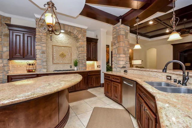 a large kitchen with kitchen island a sink stove and cabinets