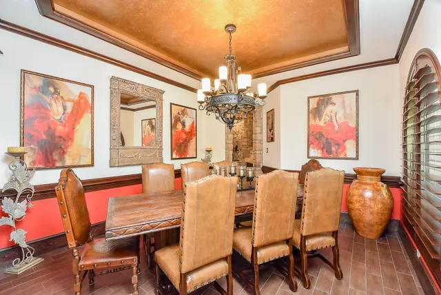 a dining room with furniture a chandelier and window