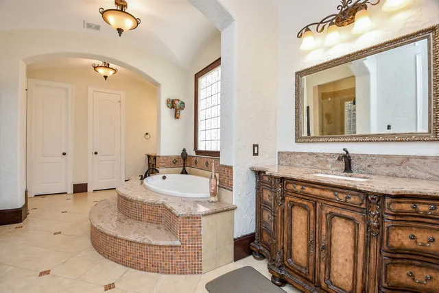 a spacious bathroom with a granite countertop sink a mirror a and a