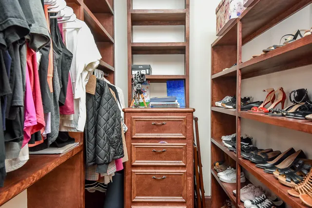 a view of walk in closet with clothes and shoes