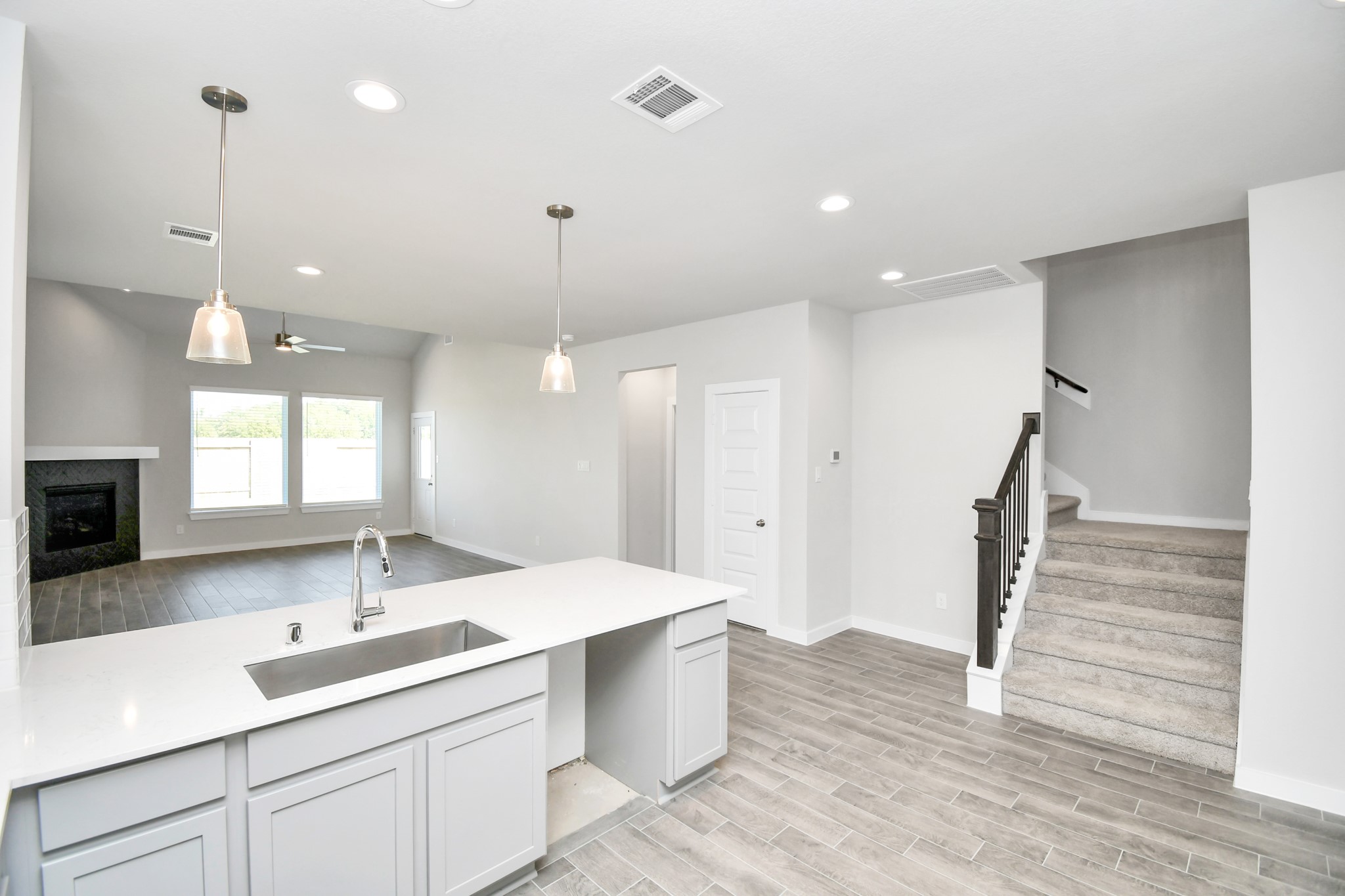 14823 Surfbird Lane Houston, TX 77049 - Photo 11 of 45 This kitchen is truly a chef's dream! This haven Boasts high ceilings, recessed & pendant lighting, stained wood cabinets, granite countertops, stainless steel appliances, a modern tile backsplash. All of this overlooks your expansive family room, creating a perfect space for culinary delights and family gatherings.