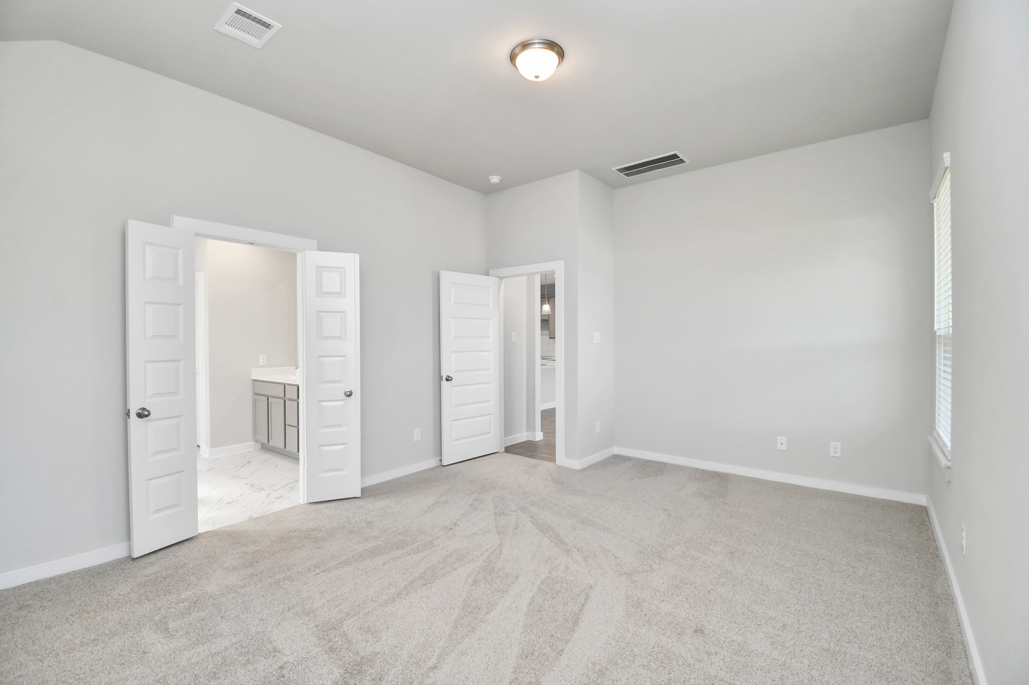 14823 Surfbird Lane Houston, TX 77049 - Photo 18 of 45 Come and unwind after a long day in this magnificent primary suite! This spacious room features plush carpet, warm paint, high ceilings and large windows with privacy blinds.