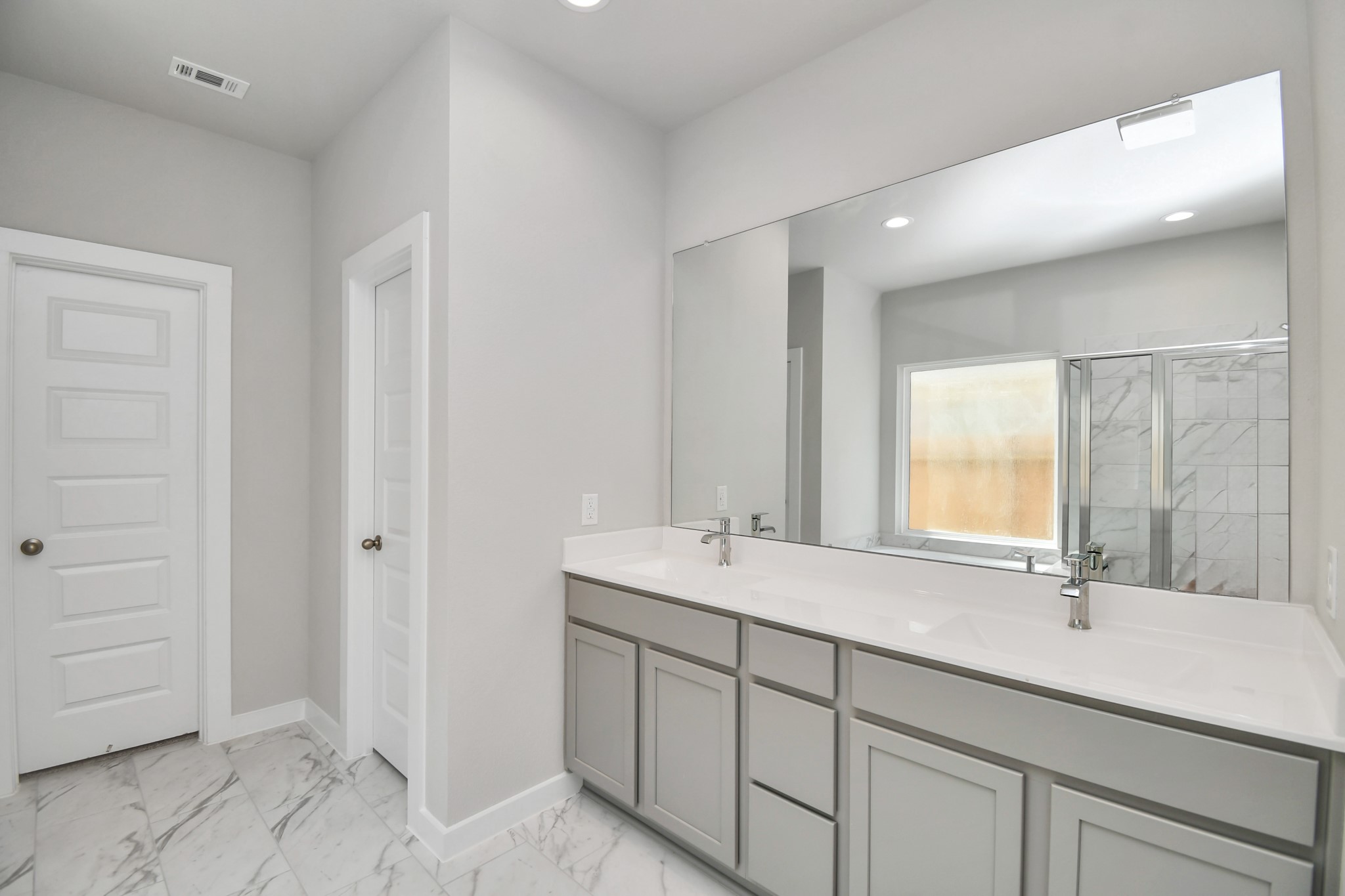 14823 Surfbird Lane Houston, TX 77049 - Photo 23 of 45 Escape to a spa-like oasis in this primary bathroom. Enjoy a walk-in shower with tile surround, a separate garden tub with custom detailing, and an elegant vanity featuring light countertops, modern hardware, and beautiful recessed lights. Experience luxury and relaxation in every detail.