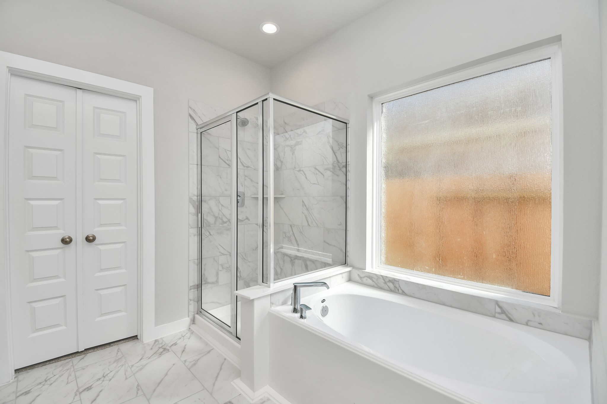 14823 Surfbird Lane Houston, TX 77049 - Photo 24 of 45 Indulge in a spa-like retreat within the confines of this primary bathroom. Delight in a spacious walk-in shower enveloped in stylish tile surround and unwind in a separate garden tub adorned with custom detailing.
