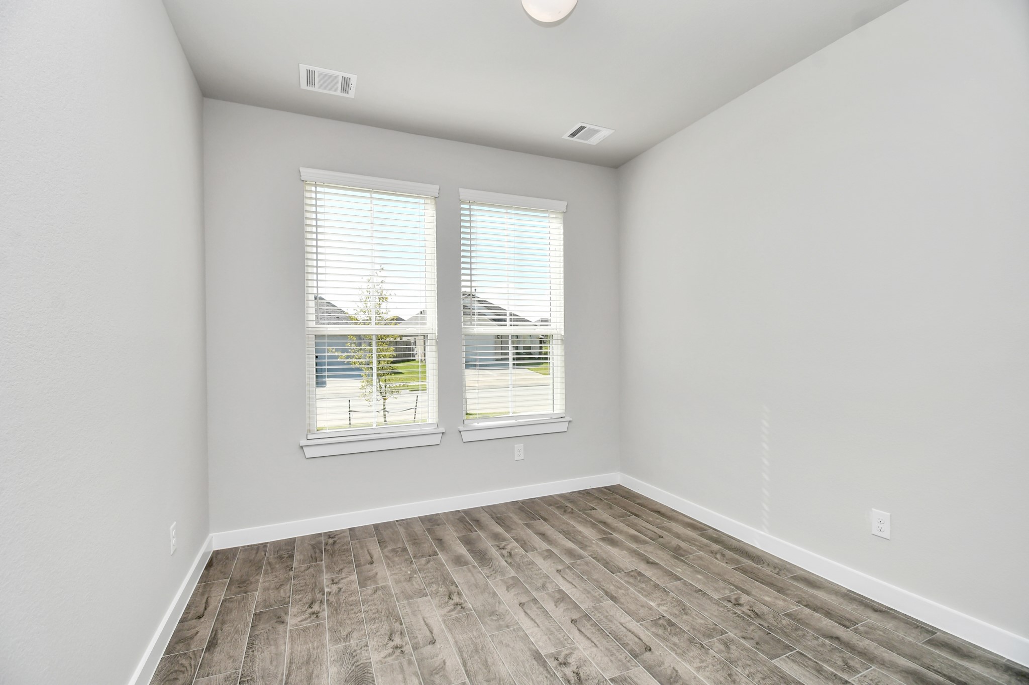 14823 Surfbird Lane Houston, TX 77049 - Photo 8 of 45 Experience the perfect blend of sophistication and warmth in this home office, boasting elegant wood-look tile flooring and flooded with natural light from expansive windows and French doors.