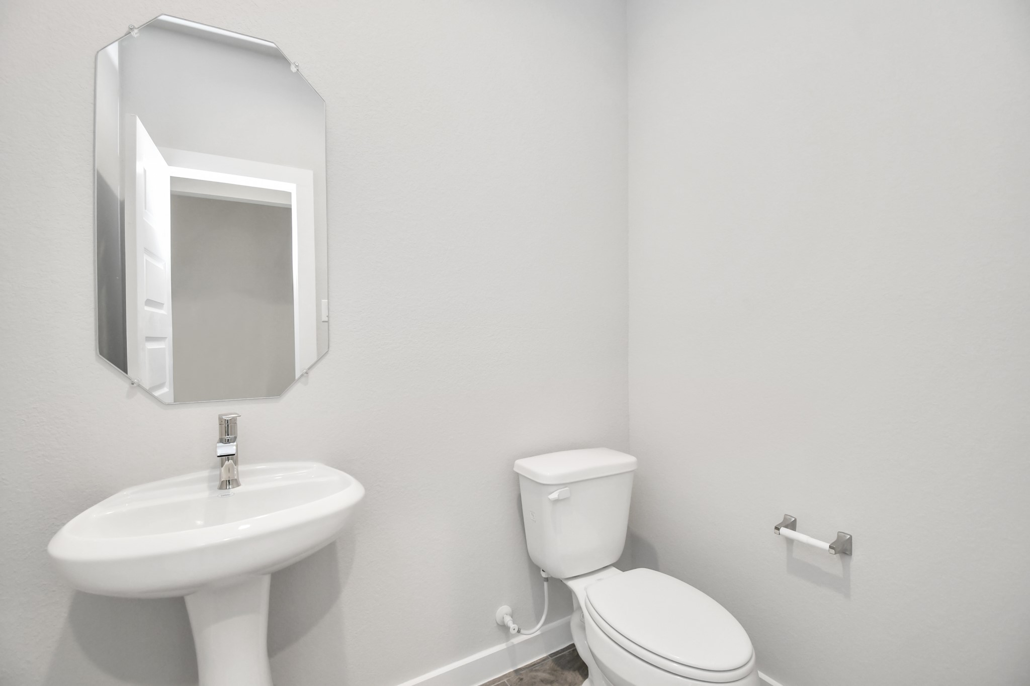 14823 Surfbird Lane Houston, TX 77049 - Photo 9 of 45 This half bathroom features a stylish pedestal sink, modern hardware, and bright recessed lighting, creating a sleek and inviting space.
