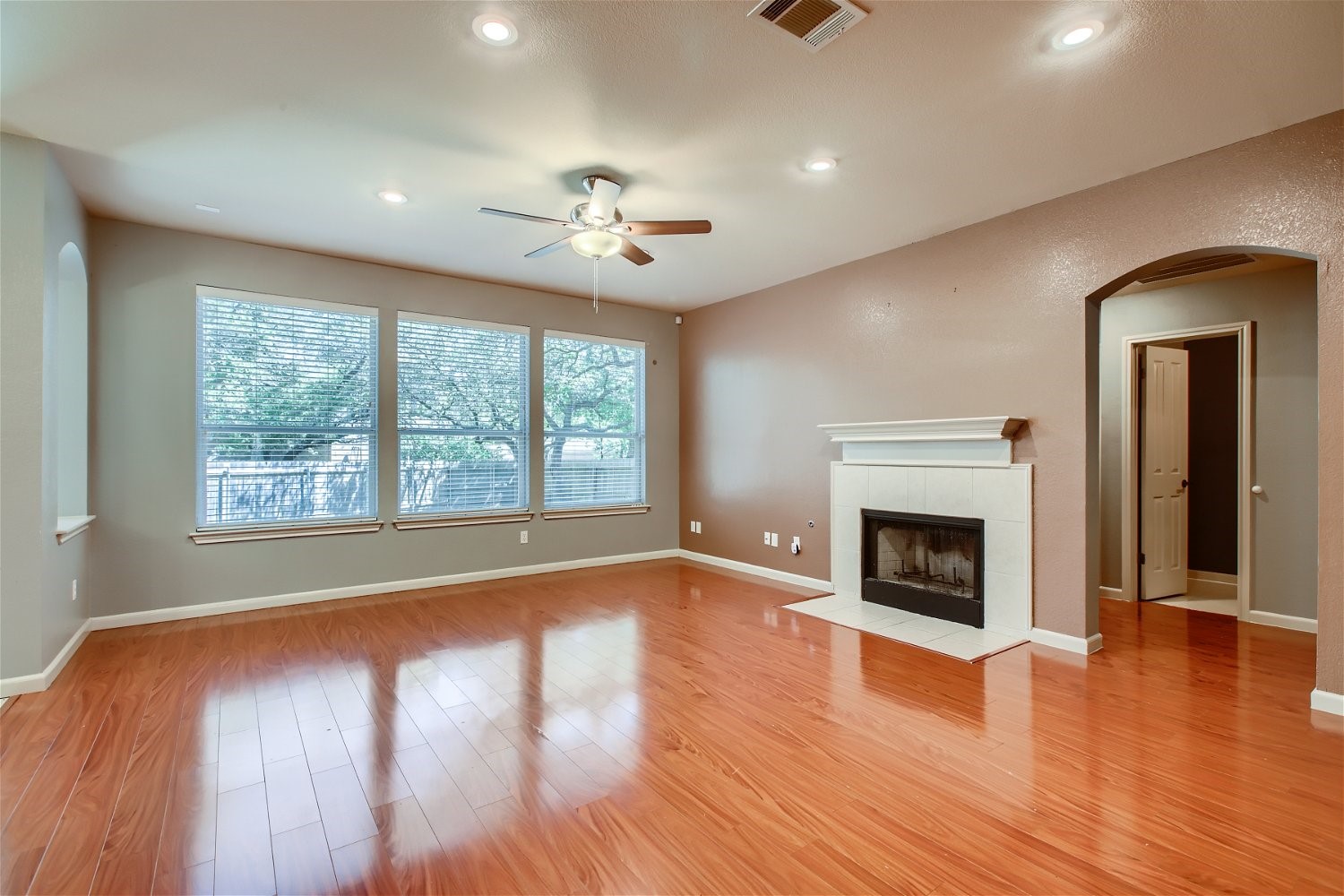 5320 Spirea Cove Austin, TX 78749 - Photo 11 of 28 a view of an empty room with wooden floor a fireplace and a window