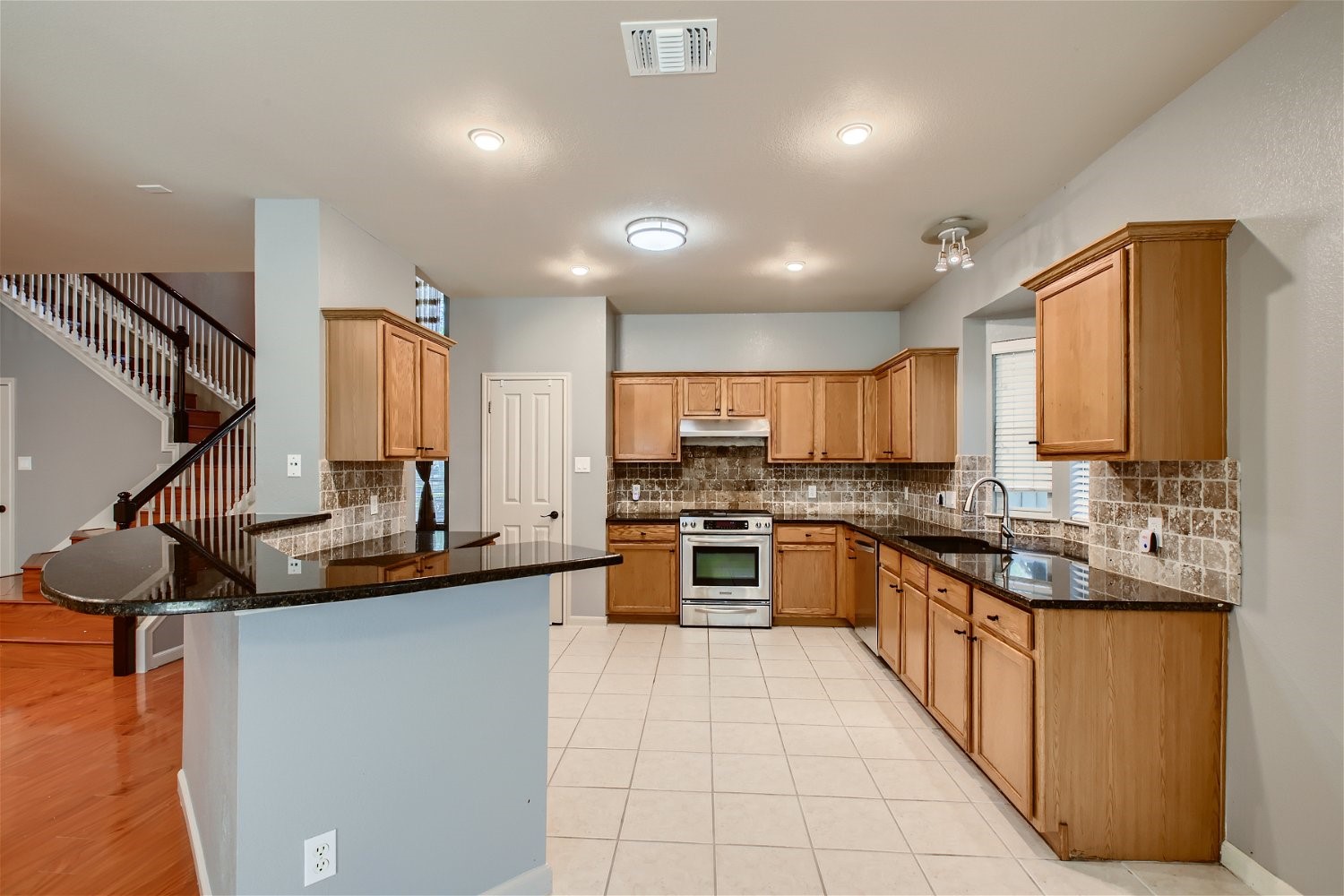 5320 Spirea Cove Austin, TX 78749 - Photo 7 of 28 a kitchen with stainless steel appliances granite countertop a sink a stove top oven a counter space and cabinets