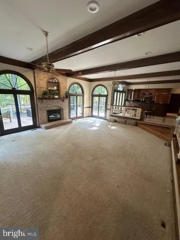 a view of a livingroom with furniture a fireplace and window