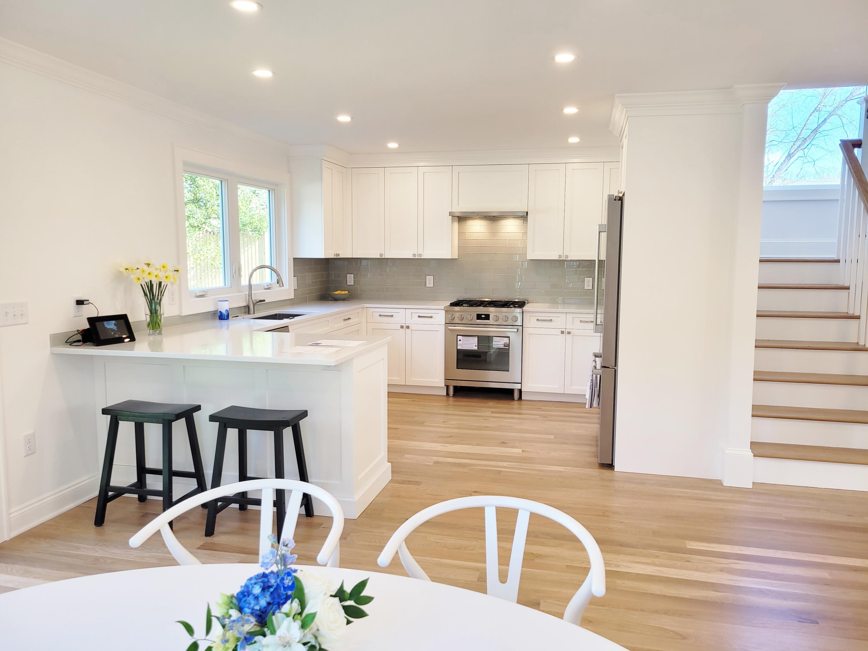 34 Crimmins Road Darien, CT 06820 - Photo 2 of 28 a kitchen with stainless steel appliances kitchen island granite countertop a stove a sink a refrigerator and white cabinets with wooden floor