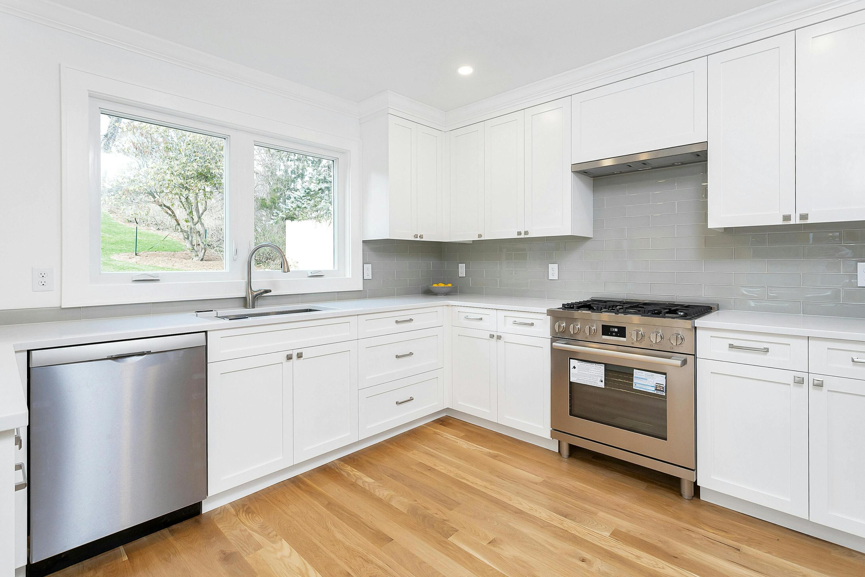 34 Crimmins Road Darien, CT 06820 - Photo 9 of 28 a kitchen with granite countertop white cabinets and white appliances with wooden floor