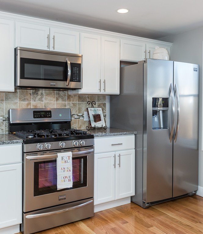 54 Oregon Street Springfield, MA 01118 - Photo 6 of 30 a kitchen with stainless steel appliances granite countertop a stove microwave and refrigerator