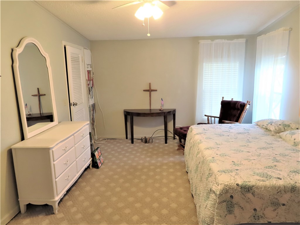 629 Marlin Circle Barefoot Bay, FL 32976 - Photo 18 of 34 a bedroom with a bed and a mirror