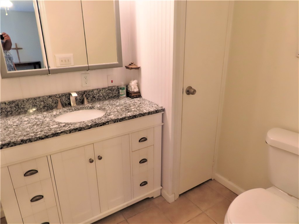 629 Marlin Circle Barefoot Bay, FL 32976 - Photo 20 of 34 a bathroom with a granite countertop toilet and sink