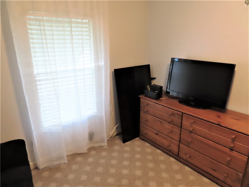 629 Marlin Circle Barefoot Bay, FL 32976 - Photo 22 of 34 a room with a flat screen tv and a dresser