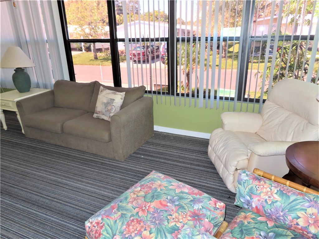 629 Marlin Circle Barefoot Bay, FL 32976 - Photo 27 of 34 a living room with furniture and a floor to ceiling window