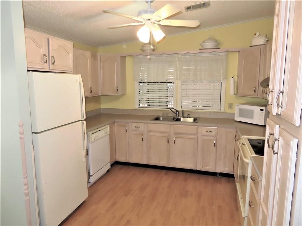 629 Marlin Circle Barefoot Bay, FL 32976 - Photo 5 of 34 a kitchen with a refrigerator a sink cabinets and wooden floor