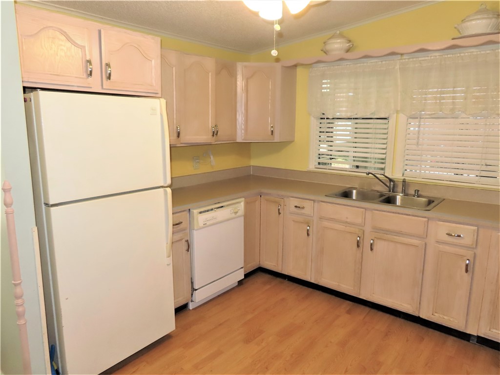 629 Marlin Circle Barefoot Bay, FL 32976 - Photo 7 of 34 a kitchen with white cabinets and white appliances