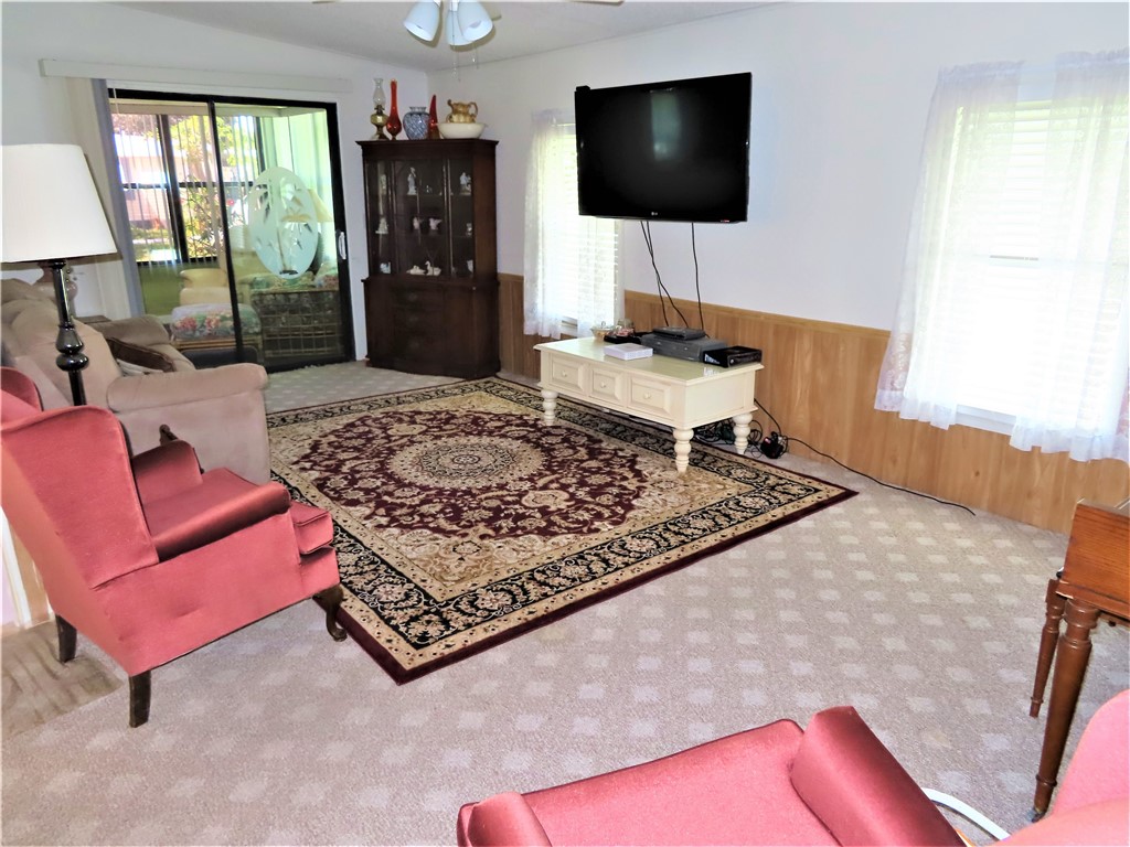 629 Marlin Circle Barefoot Bay, FL 32976 - Photo 10 of 34 a living room with a flat screen tv and a fireplace