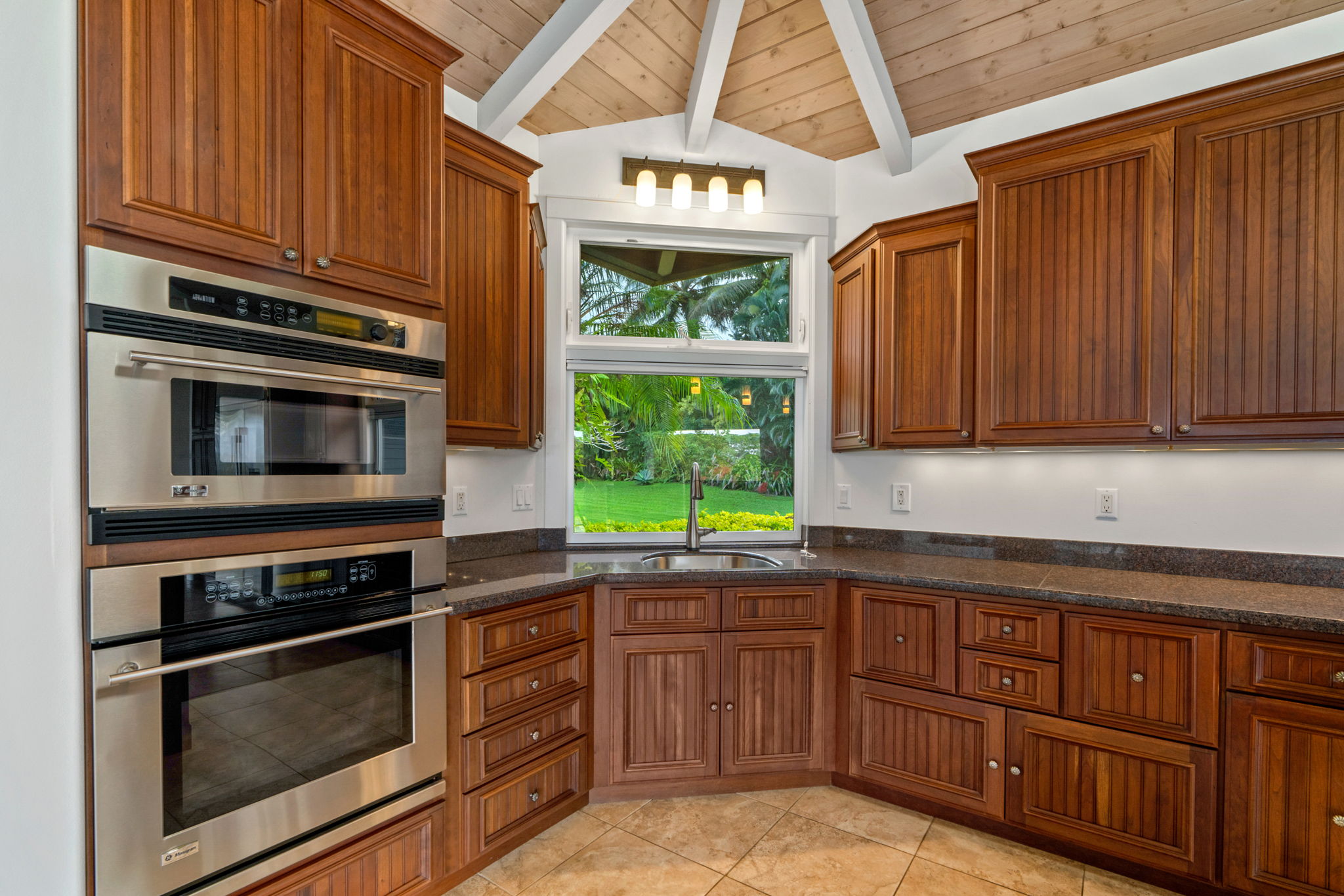 4928 Wailapa Road, Unit A Kilauea, HI 96754 - Photo 6 of 30 a kitchen with granite countertop wooden cabinets stainless steel appliances and a window
