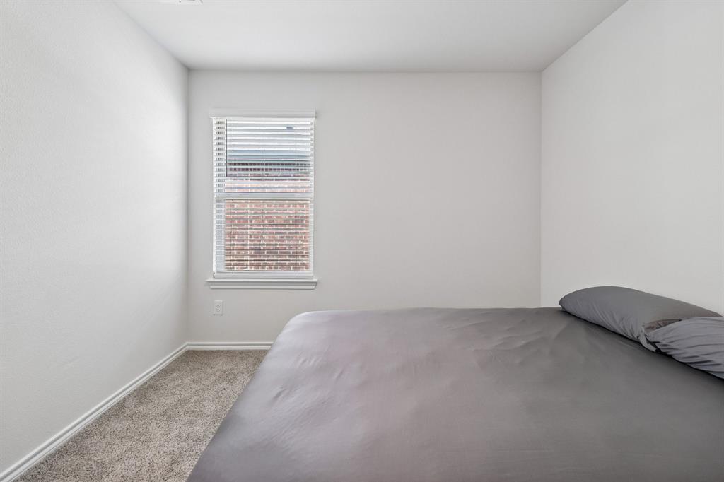 1453 Millstead Rill Road Caddo Mills, TX 75135 - Photo 20 of 40 Light-filled room featuring a single window with blinds, neutral wall paint, white baseboards, and soft carpet flooring