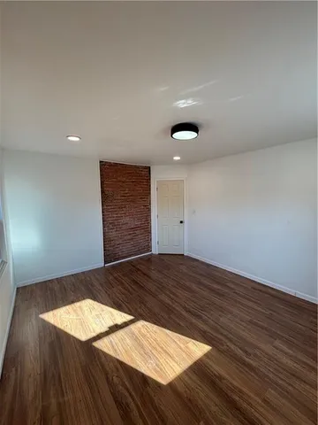 a view of an empty room and wooden floor