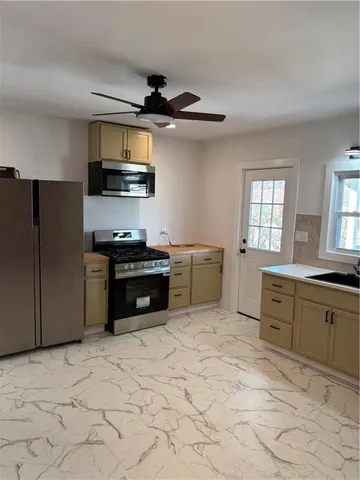 a kitchen with stainless steel appliances granite countertop a stove a sink and a refrigerator