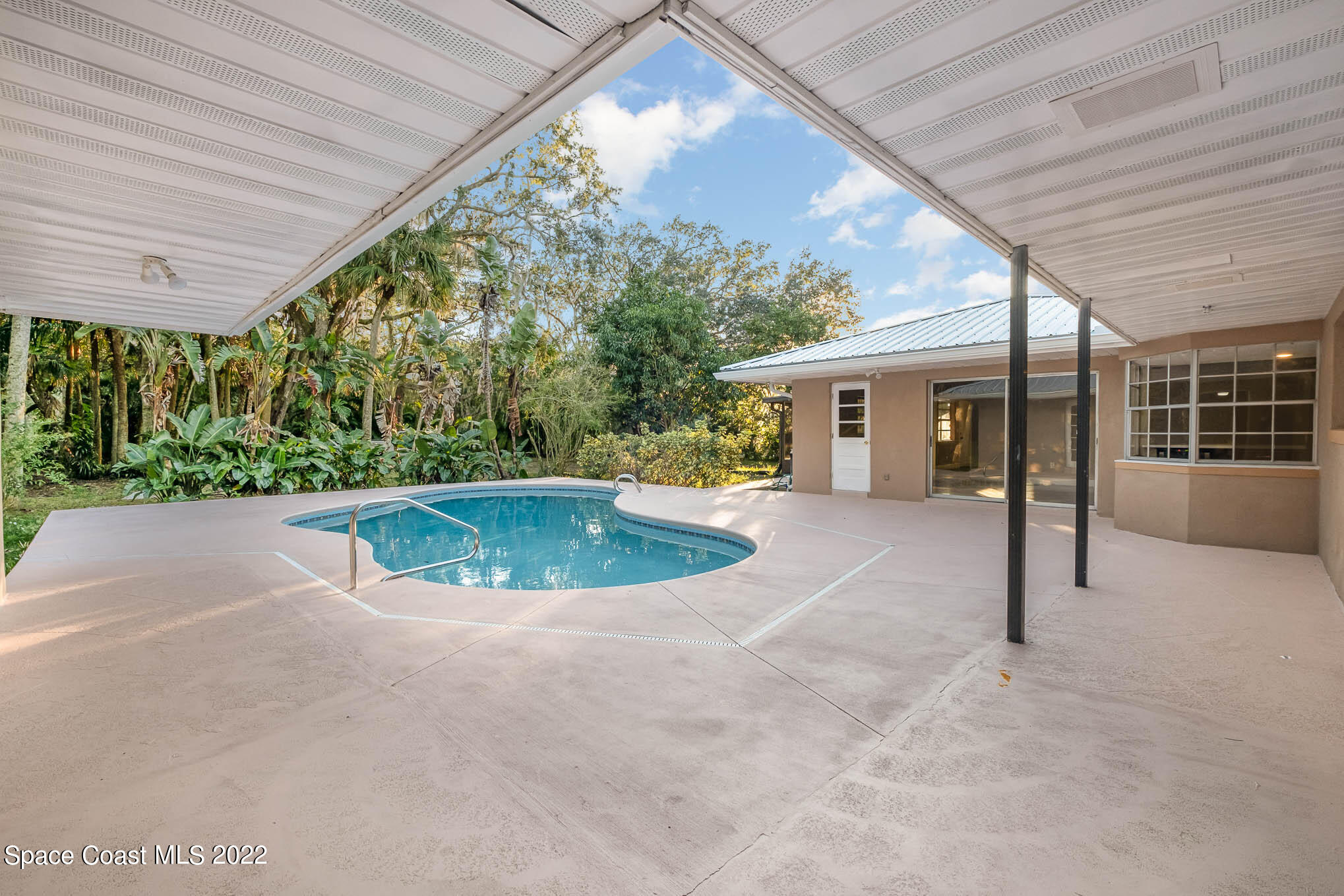 395 East Hall Road Merritt Island, FL 32953 - Photo 18 of 46 a view of a house with a swimming pool