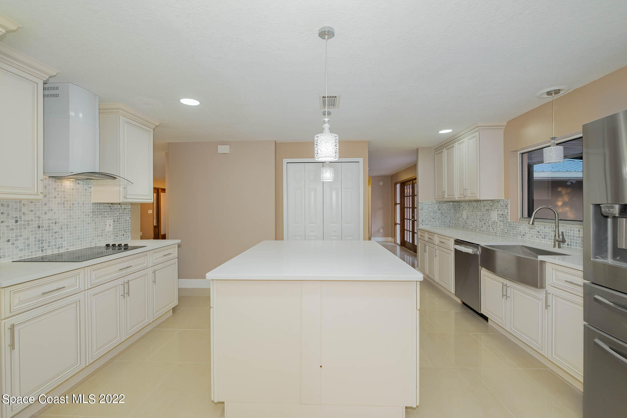 395 East Hall Road Merritt Island, FL 32953 - Photo 23 of 46 a large kitchen with stainless steel appliances kitchen island granite countertop a stove a sink a refrigerator and white cabinets with wooden floor