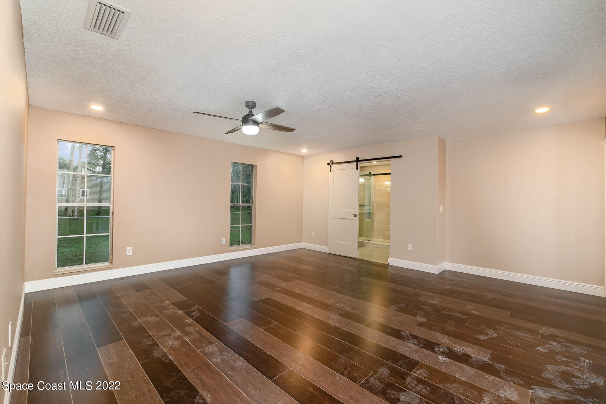 395 East Hall Road Merritt Island, FL 32953 - Photo 31 of 46 a view of an empty room with wooden floor and a window