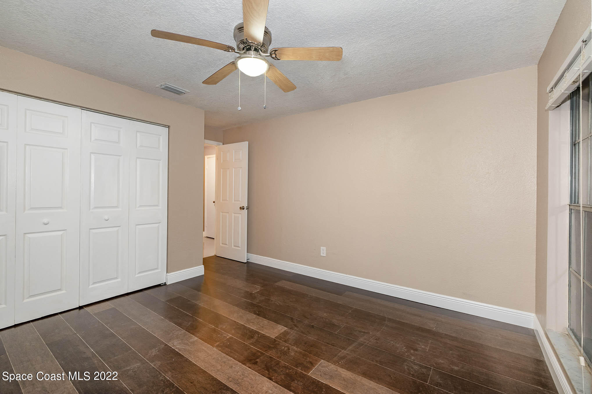 395 East Hall Road Merritt Island, FL 32953 - Photo 35 of 46 an empty room with wooden floor and fan