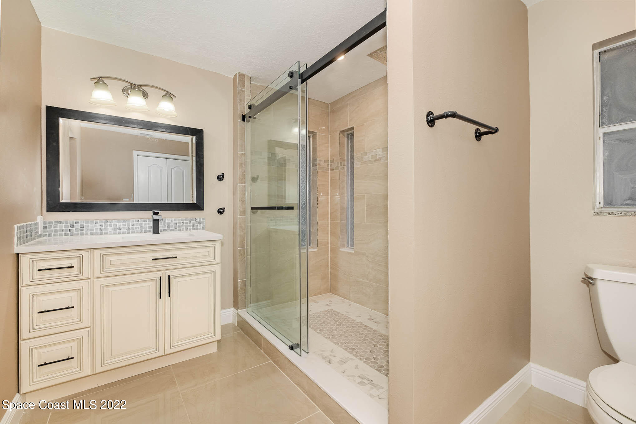 395 East Hall Road Merritt Island, FL 32953 - Photo 39 of 46 a bathroom with a shower sink and mirror