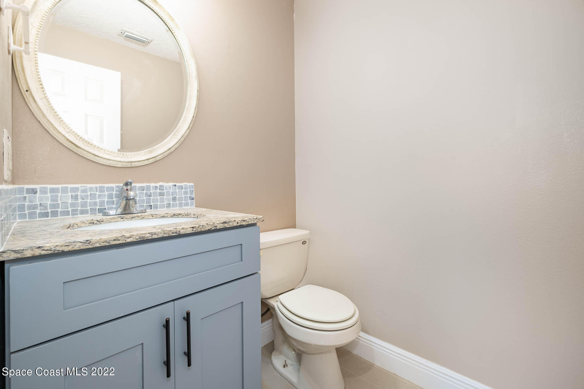 395 East Hall Road Merritt Island, FL 32953 - Photo 45 of 46 a bathroom with a granite countertop toilet sink mirror and vanity