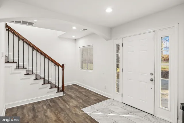 a view of a hallway with wooden floor and entryway