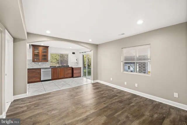 a view of a big room with wooden floor and a kitchen