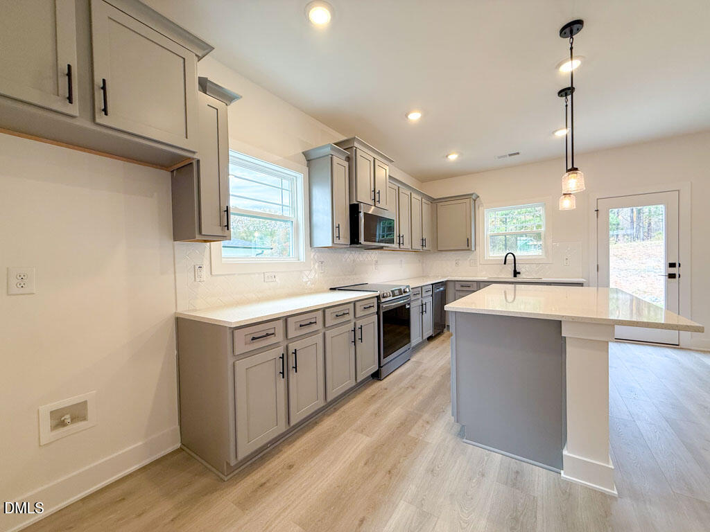 27 Decatur Drive Fuquay-Varina, NC 27526 - Photo 12 of 46 a large kitchen with stainless steel appliances kitchen island granite countertop a stove a sink and a refrigerator