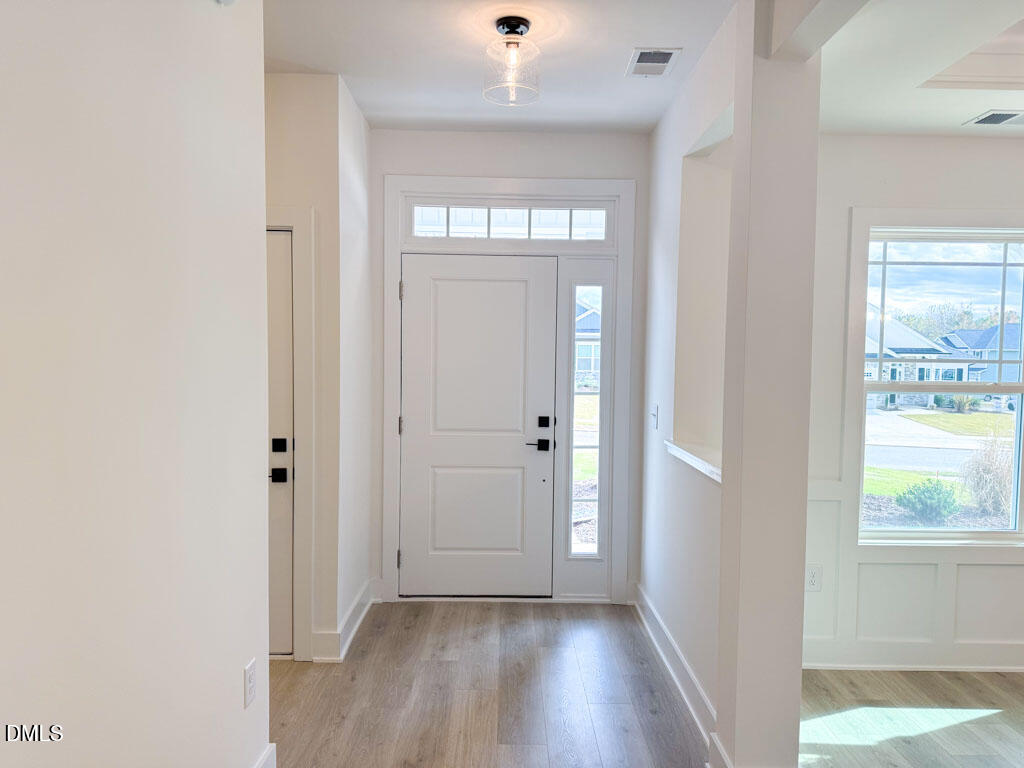 27 Decatur Drive Fuquay-Varina, NC 27526 - Photo 4 of 46 a view of a hallway with wooden floor and a window