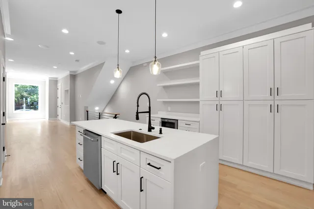 a kitchen with white cabinets and sink