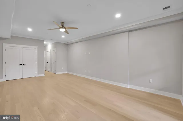 an empty room with an entryway and fan