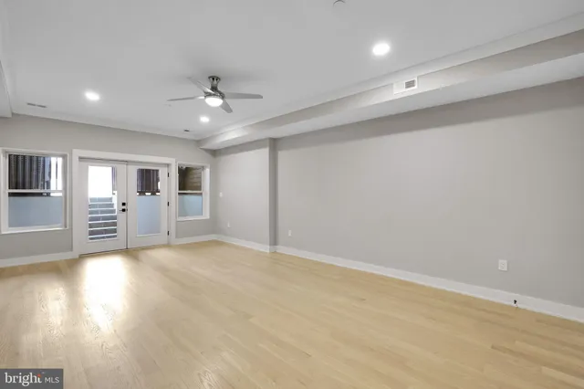 an empty room with wooden floor and windows
