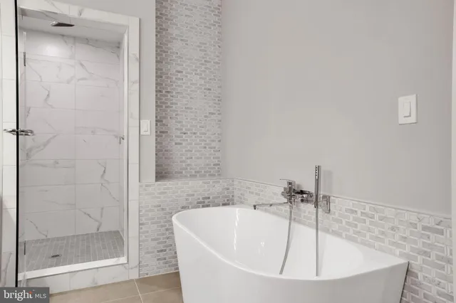 a white bath tub sitting next to a shower